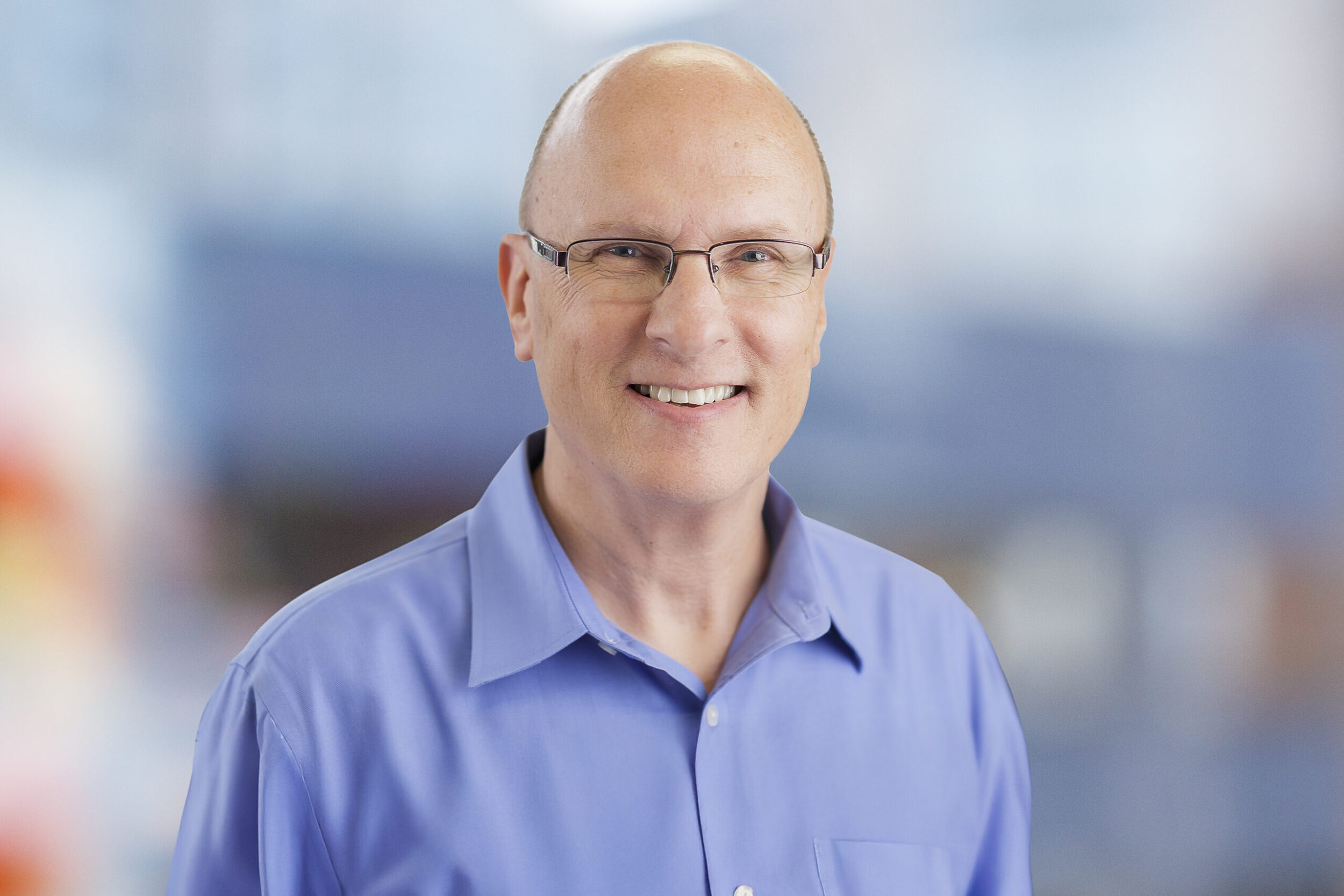 Professional headshot of Dave Larter smiling, captured in a bright and professional setting.