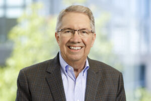 Professional headshot of Mike Esterday smiling against a neutral backdrop.