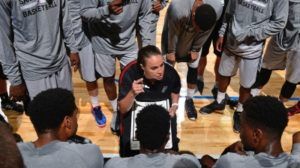 Spurs basketball team in huddle listening to Becky Hammon coach