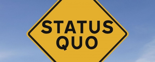 Caution sign that says "status quo"