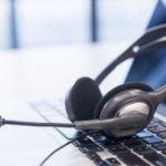close up headset of call center and laptop for communication telephony VOIP technology on office desk in monitoring room for network operation job concept