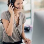 woman using a headset while sitting at her desk in the office