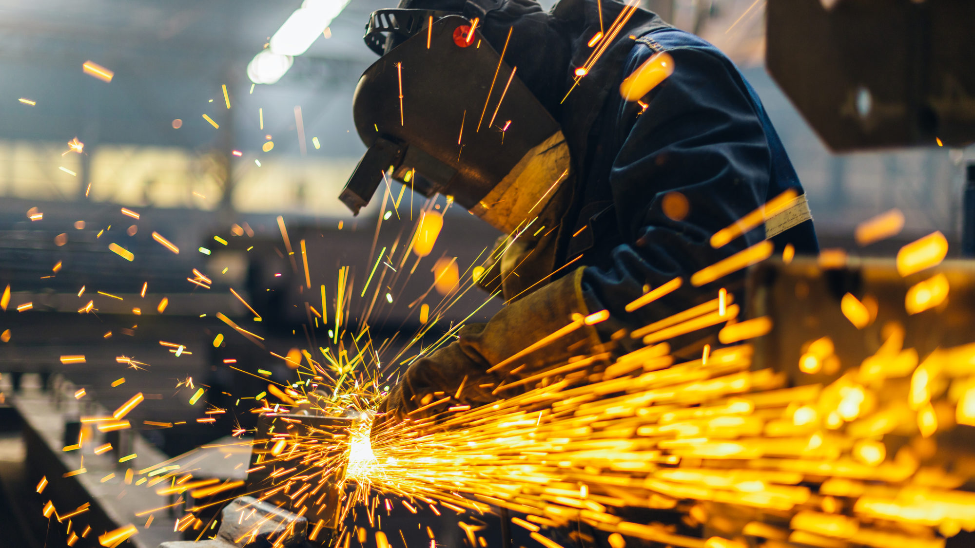 Metal worker using a grinder