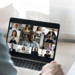 Back view of male employee have webcam conference with colleagues