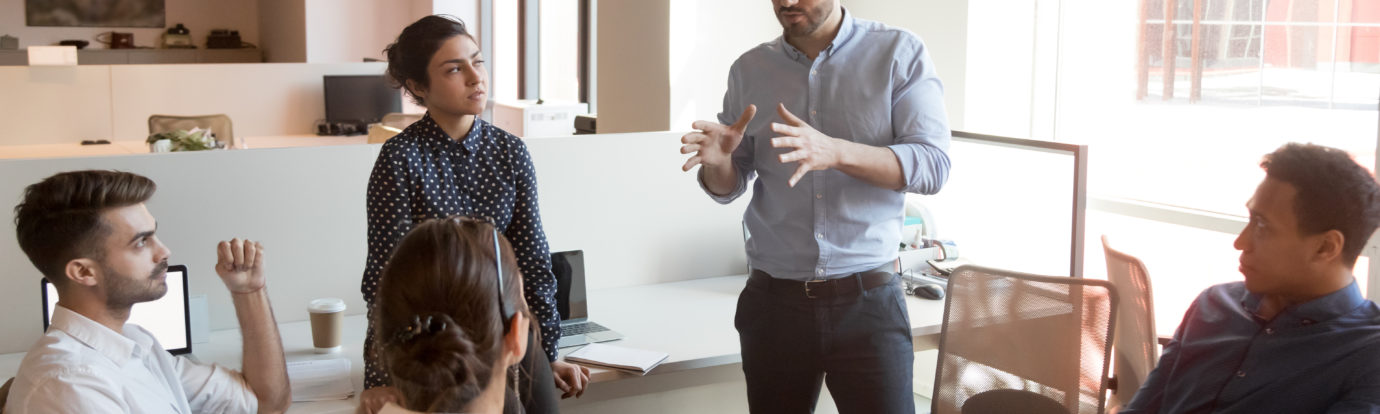 man coaching his coworkers in meeting