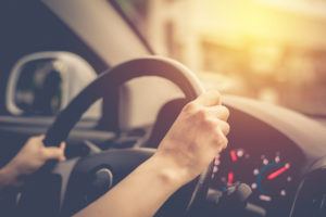 female hands on steering wheel of car