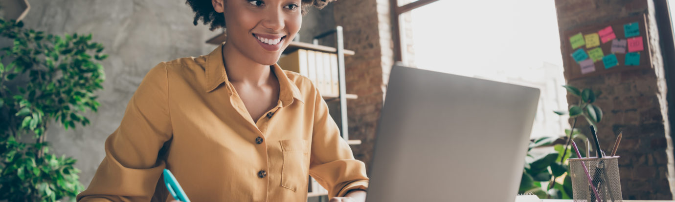 black women taking notes during virtual training on laptop