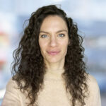 Professional headshot of Amelia Strother smiling, captured in a bright, modern indoor setting.