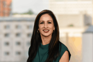 Professional headshot of Elisa Matthews smiling against a clean white background.