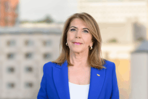 Professional headshot of Angelina smiling, set against a simple, high-key white background.